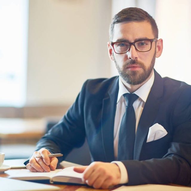 Elegant leader Confident trader in elegant suit sitting in cafe